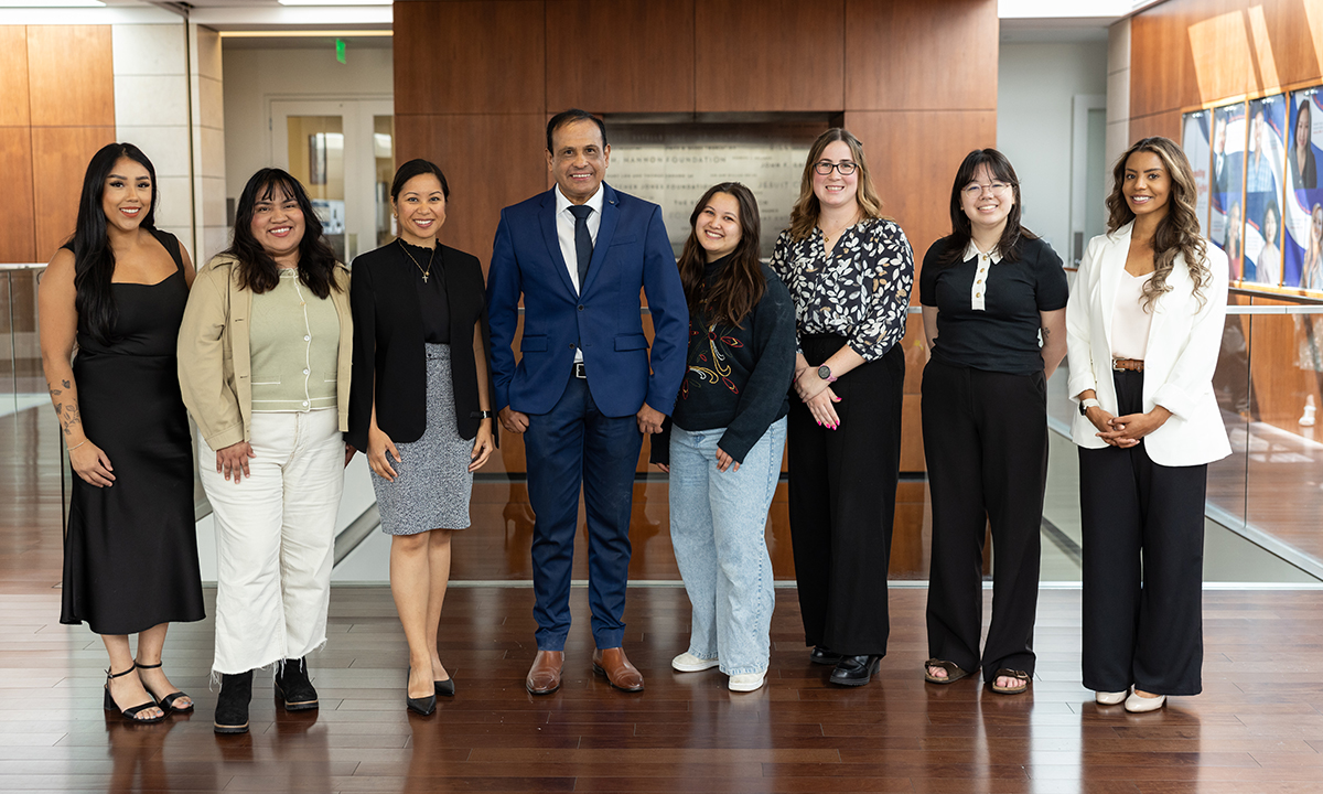 Student winners of the research awards standing in a line in the library atrium